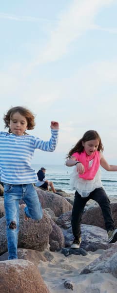 Børn På Sten Ved Stranden