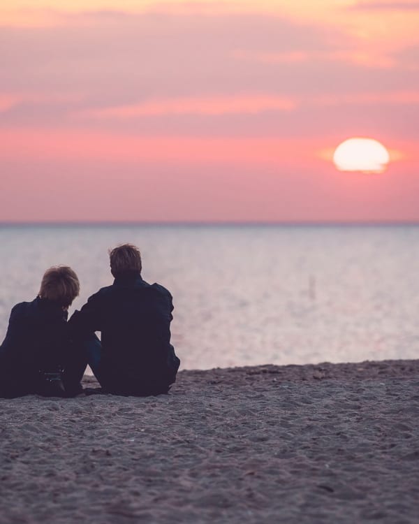 Par Sidder På Stranden Solnedgang